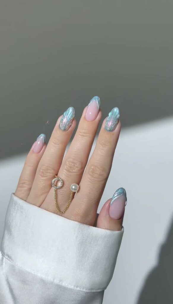 Ocean blue with shells nails with a shimmer finish, perfect for an aquatic-inspired look.