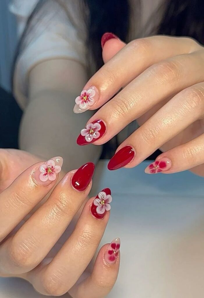 Hand-painted florals on a cherry red base nails